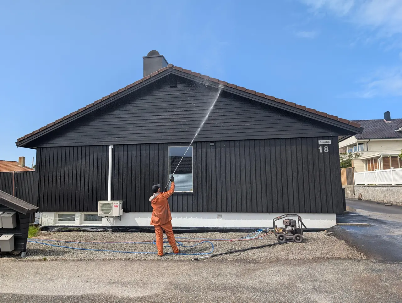 Fasadevask av mørk trehusfasade